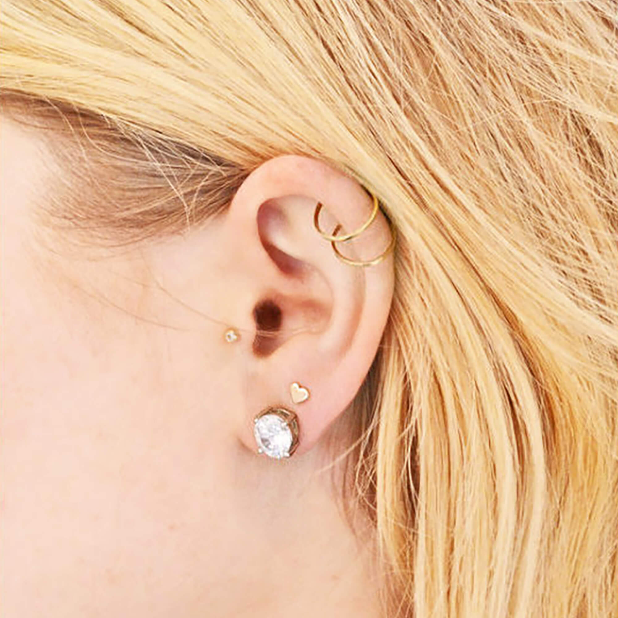 After image of woman whose earlobes were drooping and sagging from heavy diamond stud earrings, lifted by Chrysmela Catch Earring Backs with discs