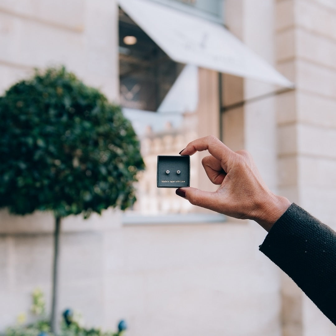 Box of Chrysmela Catch held up against a luxury boutique background