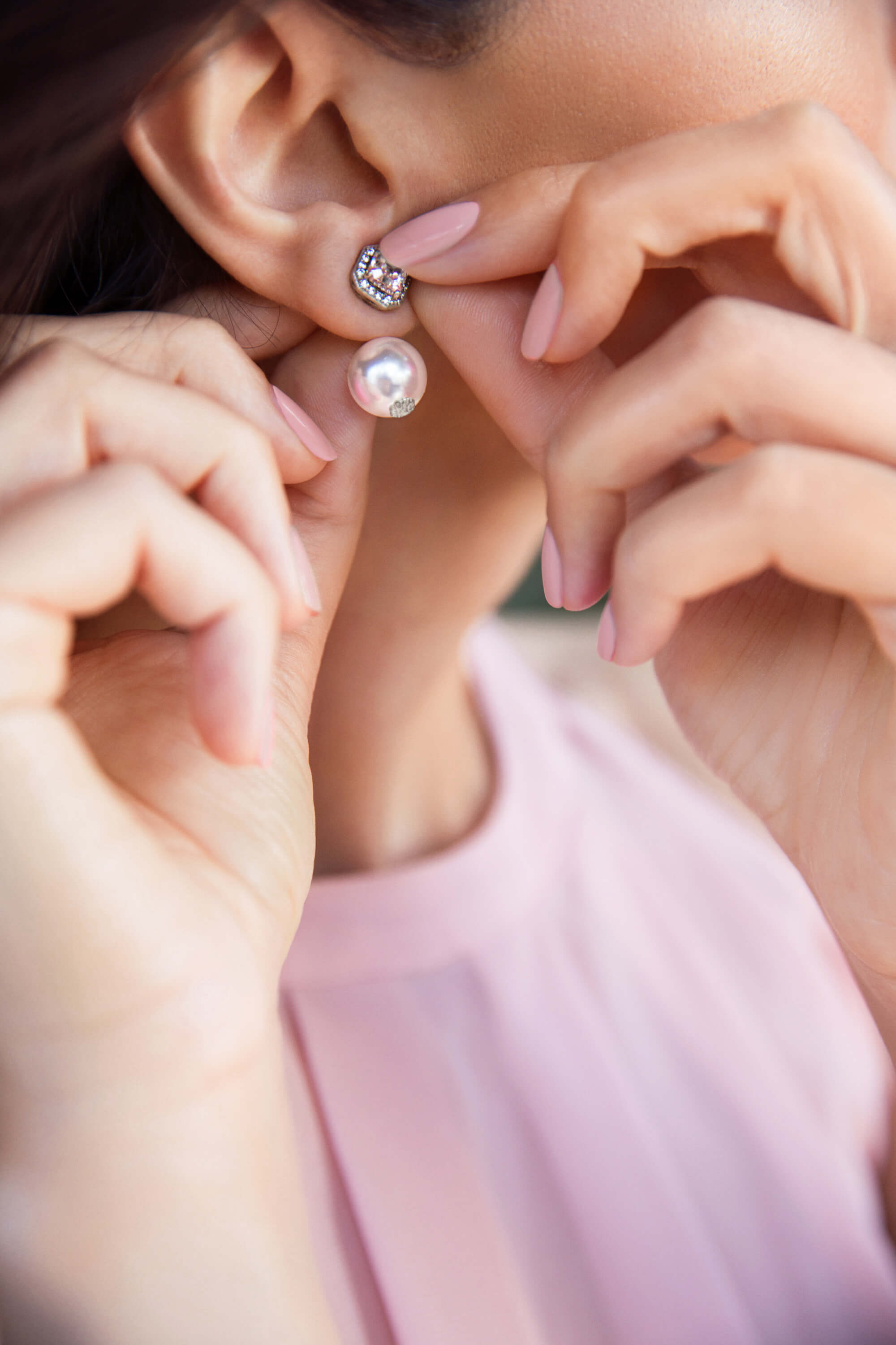 Woman wearing Chrysmela Duchess Pearl Earring jackets wearing pink clothing and nails